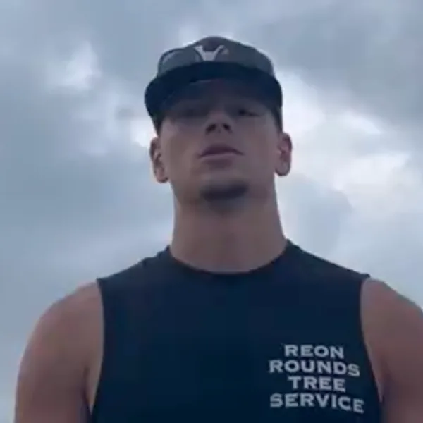 Aaron Schmitz on camera in front of a cloudy sky