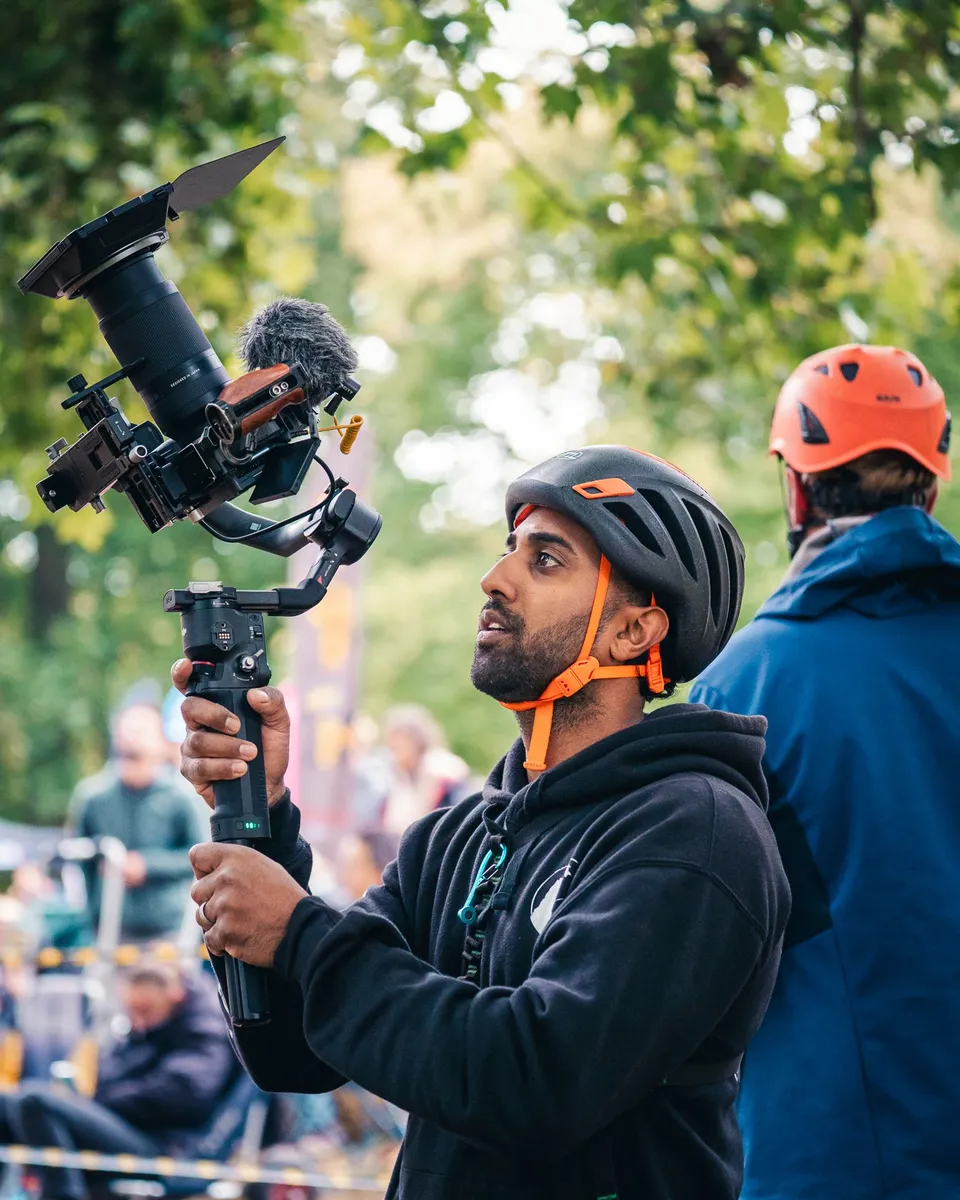 Simeon Balsam filming with a camera rig at a tree climbing event